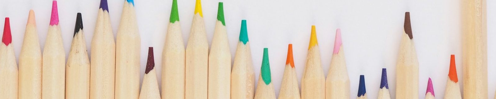 colored pencil lined up on top of white surface